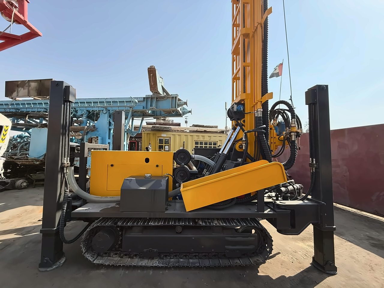Yellow crawler-mounted drilling rig with its mast upright