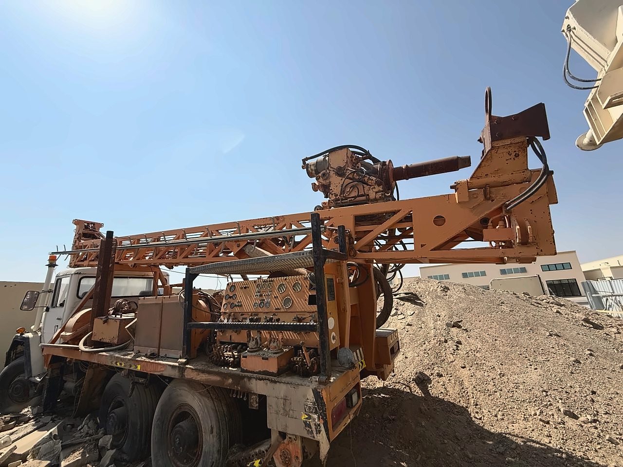 Truck-mounted drilling rig with an orange mast